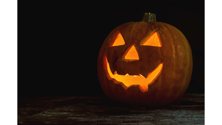 Close-Up Of Illuminated Jack On Lantern On Table Against Black Background