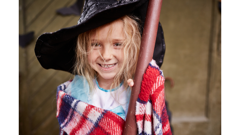Portrait of laughing little girl wearing witchâ