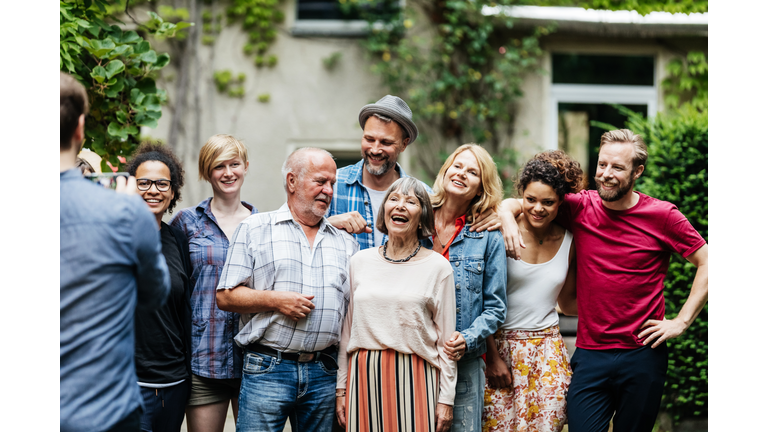 Man Taking Group Photo Of Family At BBQ