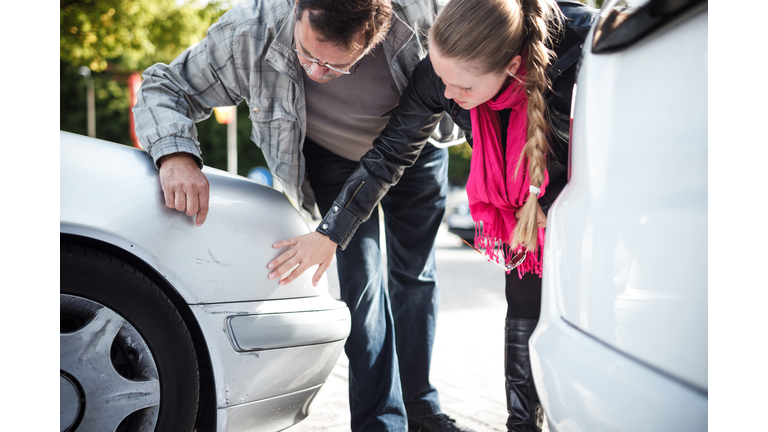 Man and woman looking car after accient.