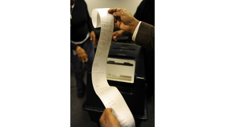 An election official looks at an optical