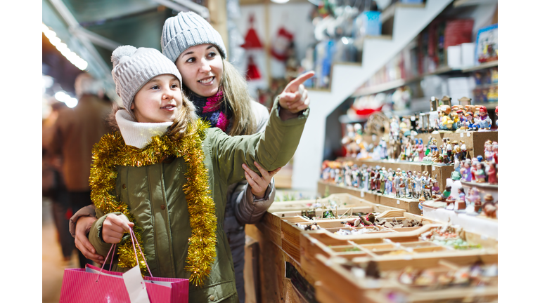 Girl with woman choosing Christmas gifts for family