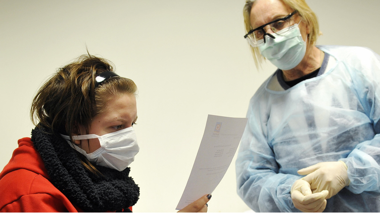 A student (L) is given a note by a docto