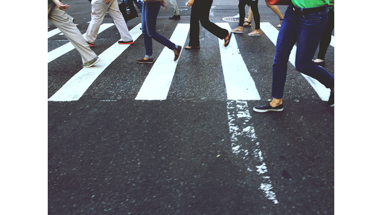 Low Section Of People Walking On Zebra Crossing In City