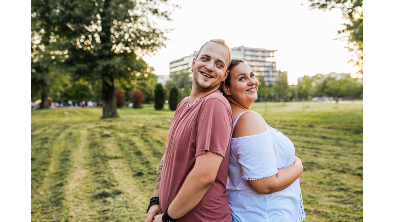 Cheerful overweight couple expressing romance in nature