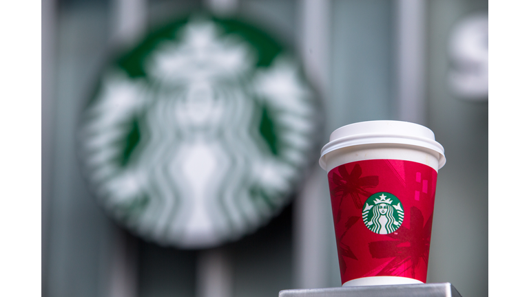 A paper coffee cup and Starbucks logo.   