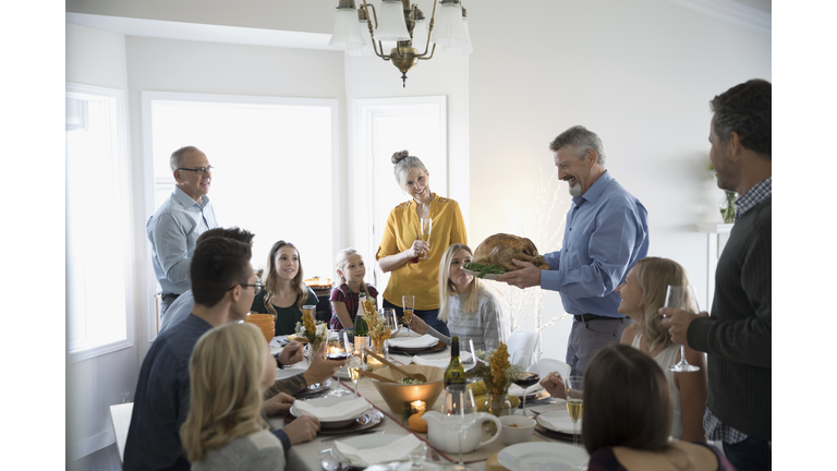  Thanksgiving turkey with family and friends at dinner table