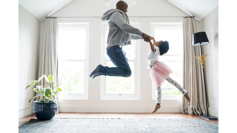 Father and daughter jumping while doing ballet