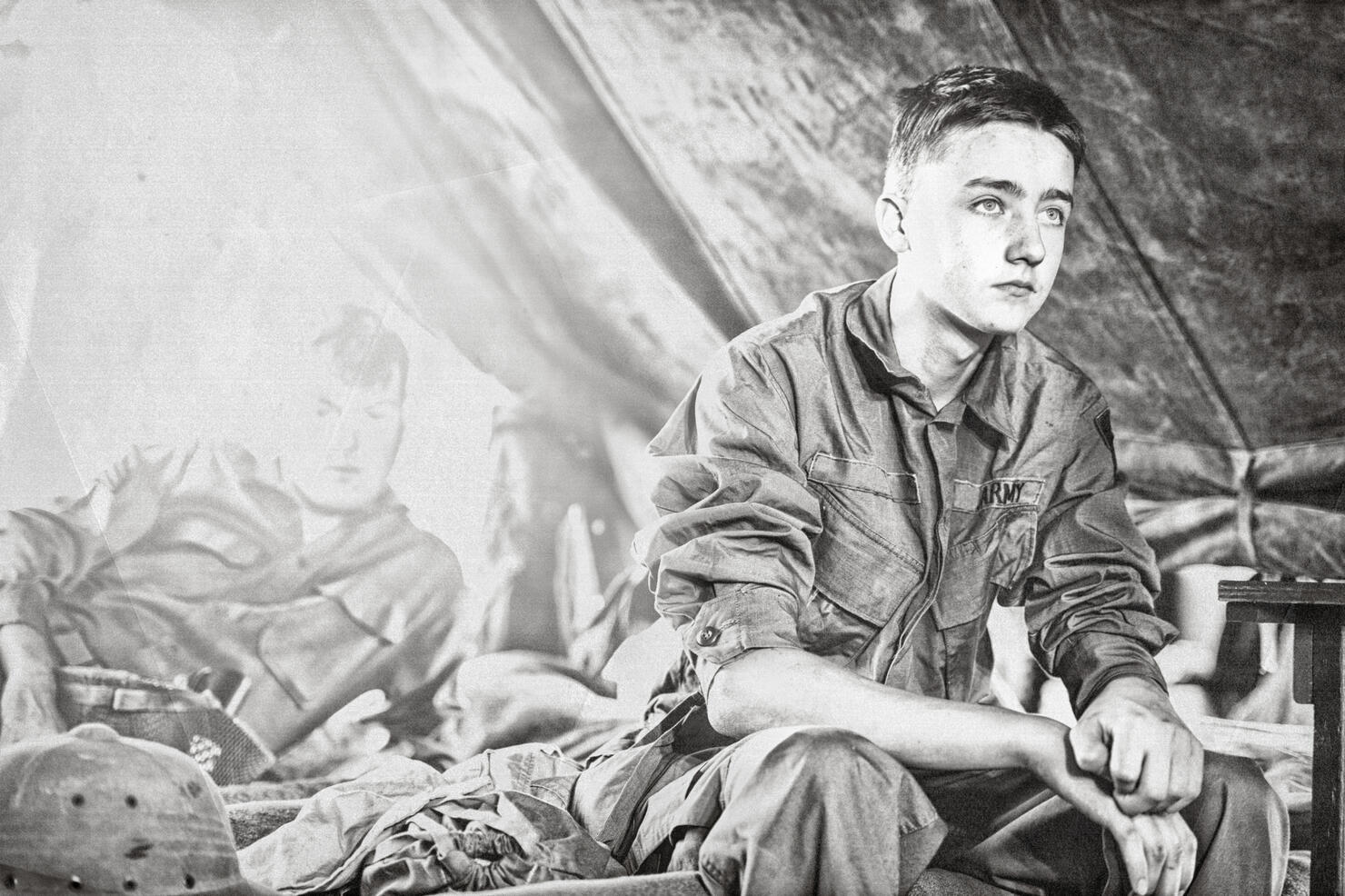 Young WWII Infantryman Sitting On A Cot In His Tent