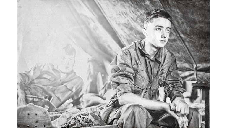 Young WWII Infantryman Sitting On A Cot In His Tent