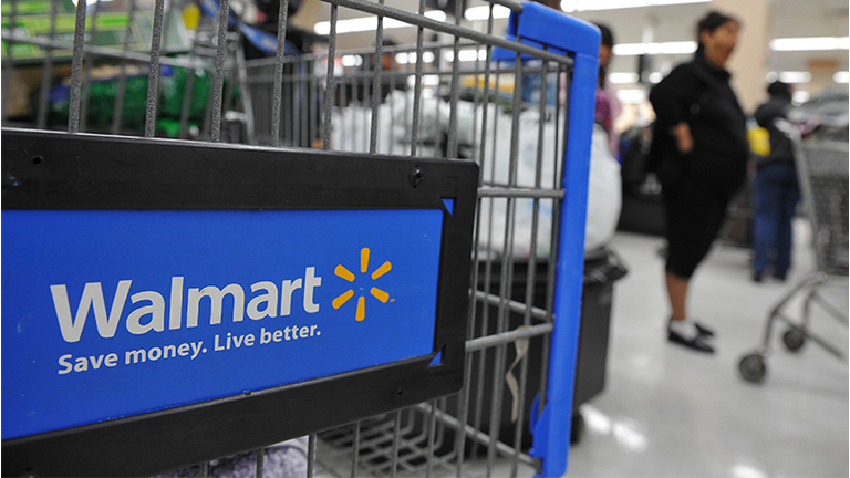 Shoppers wait in line to pay for their p