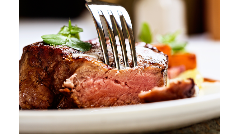 Tender and juicy, a fork pierces grilled beef fillet
