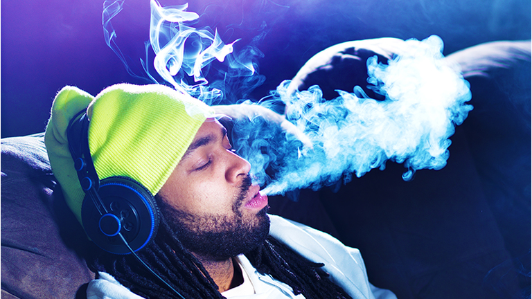 cool man smoking marijuana on his couch