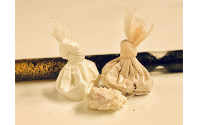 Cocaine, heroin, and methamphetamine with stem pipe over white background