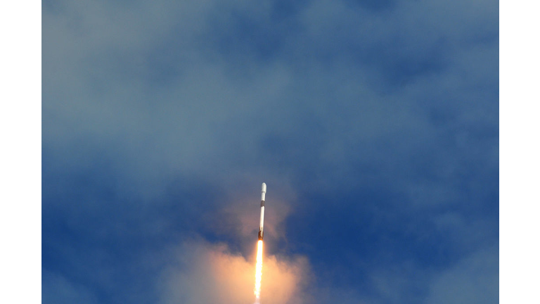 A SpaceX Falcon 9 rocket heads into the clouds after