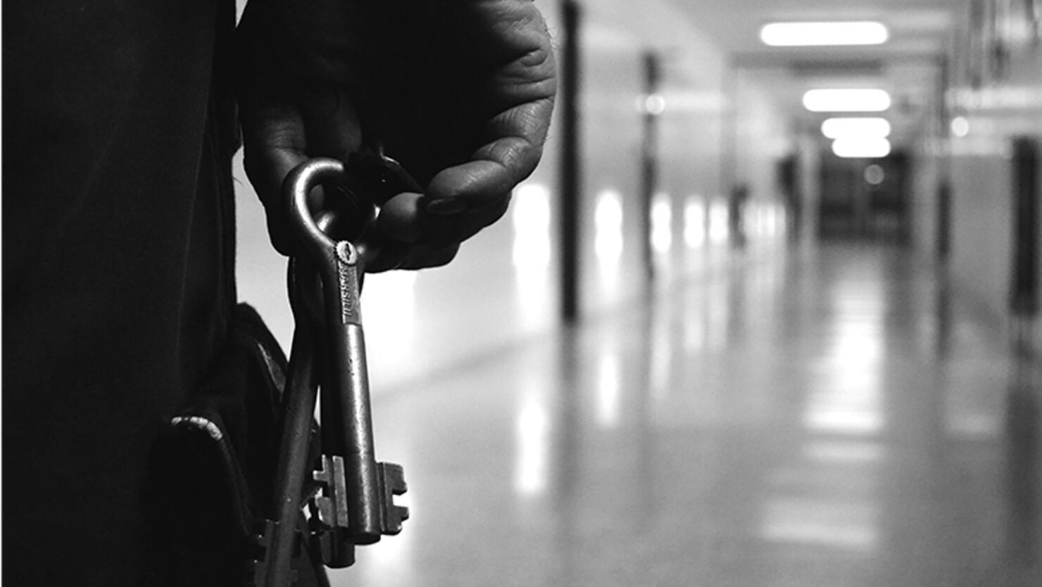 Cropped image of man holding keys in corridor