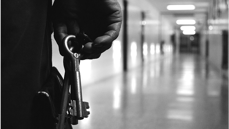 Cropped image of man holding keys in corridor