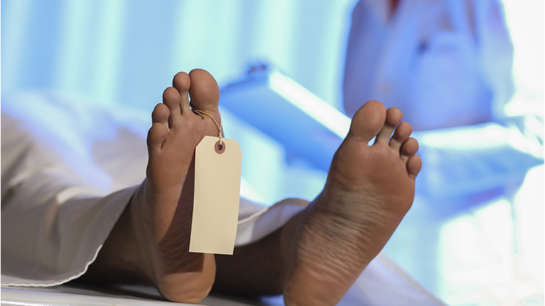 Medical Examiner with corpse in morgue.