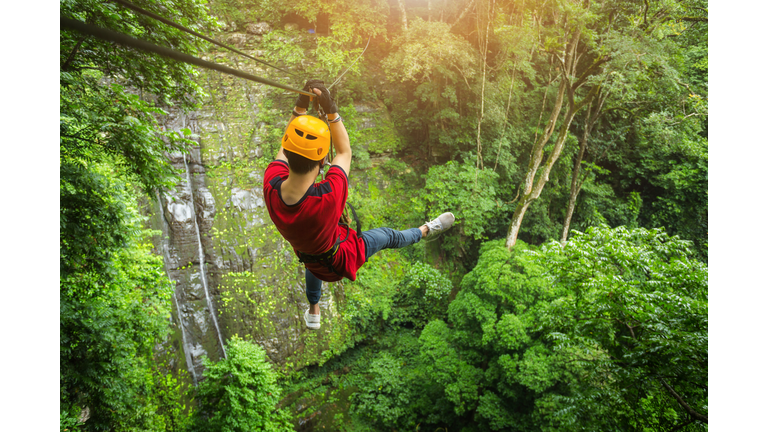 Freedom adult Man Tourist Wearing Casual Clothing On Zip Line Or Canopy Experience In Laos Rain Forest