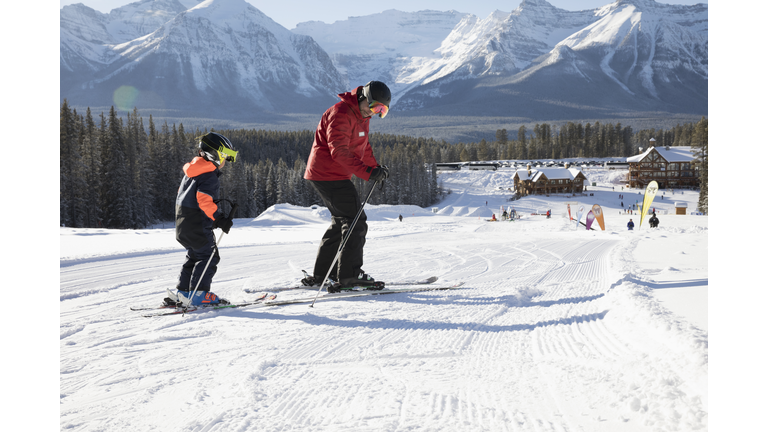 Boy receiving ski lesson from ski resort instructor