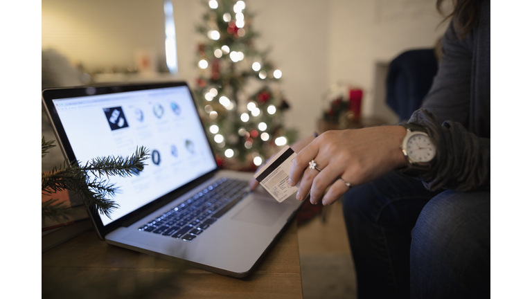 Close up young woman online Christmas shopping at laptop