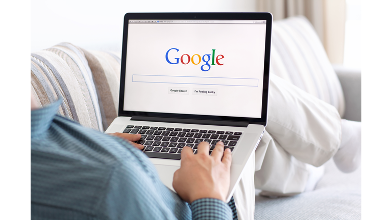 man sitting the MacBook retina with site Google on screen