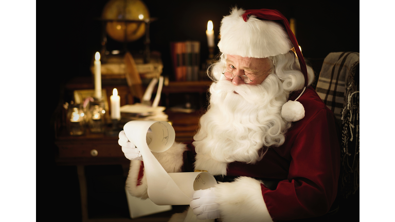 Portrait of Santa Claus reading childs letter and winking