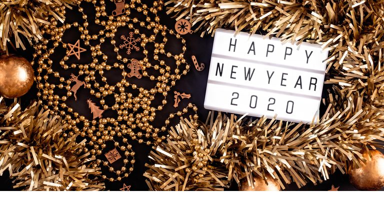 Close-Up Of Happy New Year Sign With Christmas Decoration Against Black Background