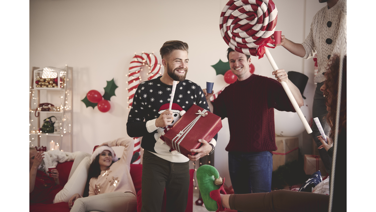 Young man singing with pretend microphone at christmas party