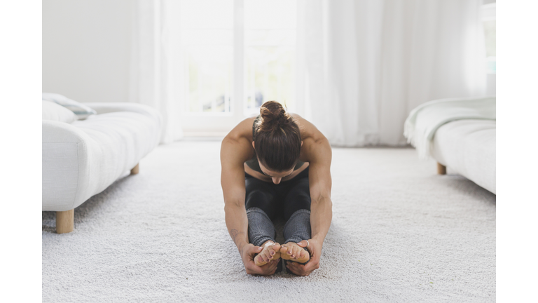 Woman sitting on the floor practicing yoga