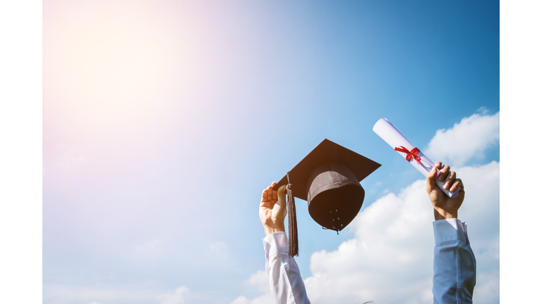 Low Angle View Of Man Holding Graduation Cap
