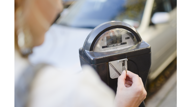 USA, New York State, New York City, Brooklyn, Woman inserting coin into parking meter