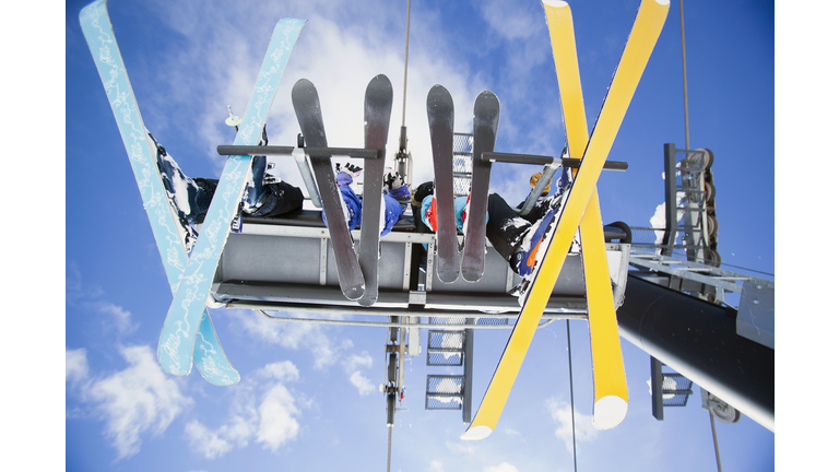 Family of skiers on ski lift seen from below