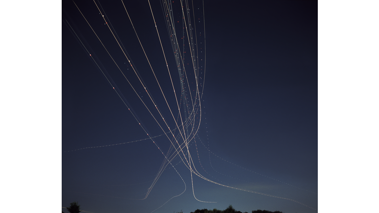 Light trails from aircraft taking off in night sky