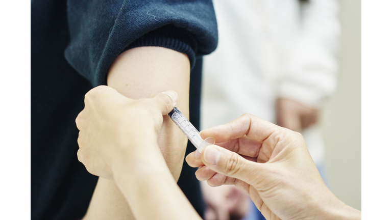 Female doctor giving a vaccination shot to a young woman