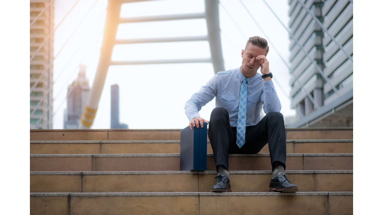 Frustrated stressed young Asian business man feeling tired and exhausted with job