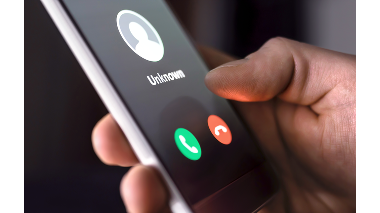 Phone call from unknown number late at night. Scam, fraud or phishing with smartphone concept. Prank caller, scammer or stranger. Man answering to incoming call.