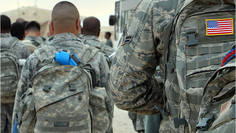 US army soldiers queue to board a plane