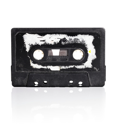 Close-Up Of Weathered Audio Cassette Over White Background