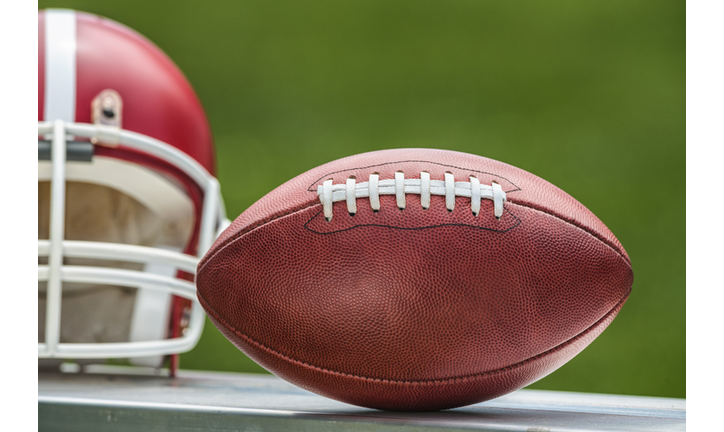 Close-up of a Pro American football and helmet sitting on bench