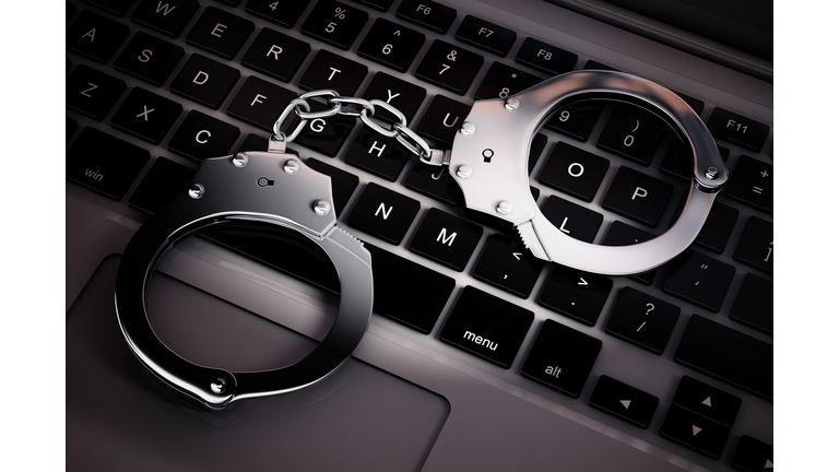 Cyber Crime Concept. Handcuffs on Laptop Computer. 3d Rendering