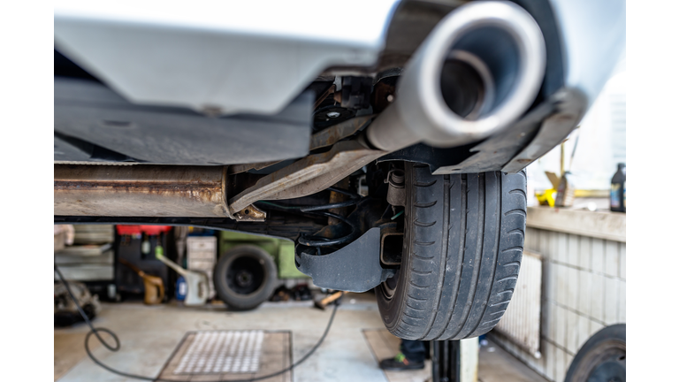 The exhaust system in the car seen from below, the car is on the lift in the car workshop.