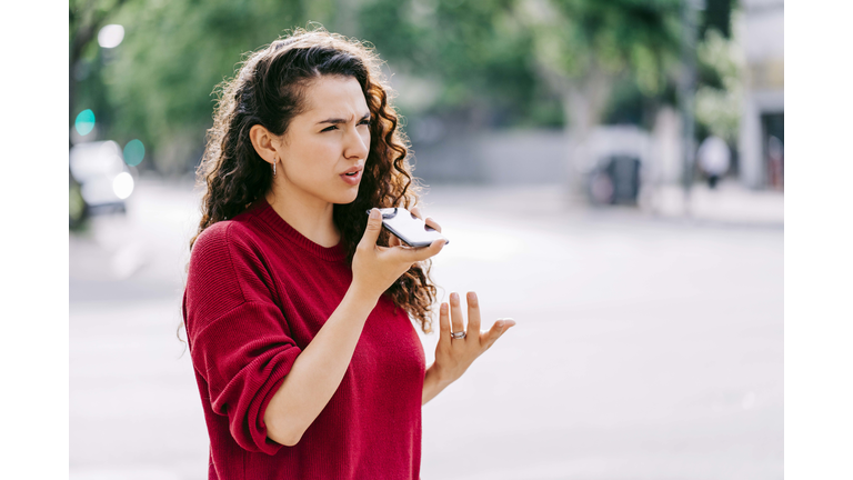 Woman with neck injury using smart phone on street