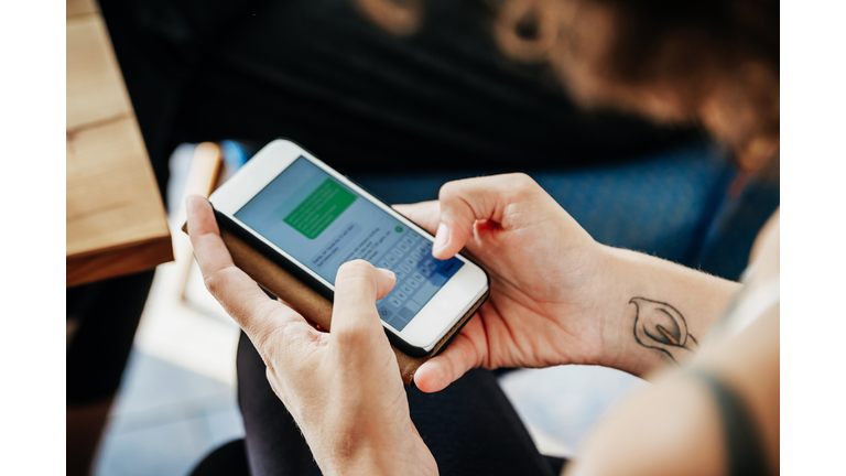 Close Up Of Woman Messaging Friends Using Smartphone