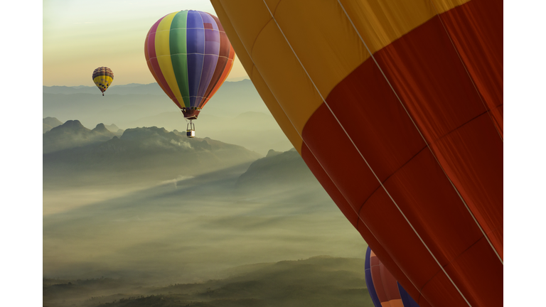 Colorful hot-air balloons flying over the Doi Luang Chiang Dao with sunrise and morning mist at Chiang mai