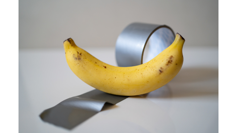 Banana and duct tape on white background
