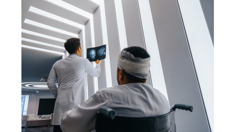 Young doctor man looking x-ray of the patient's skull