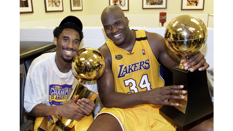 Kobe Bryant (L) of the Los Angeles Lakers holds th