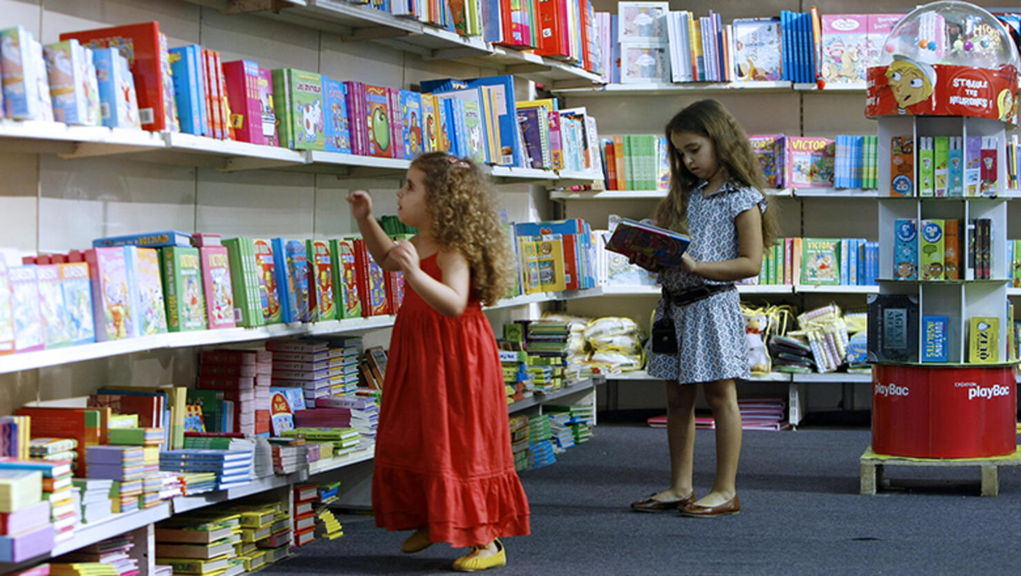 Two girls pick books from the children's