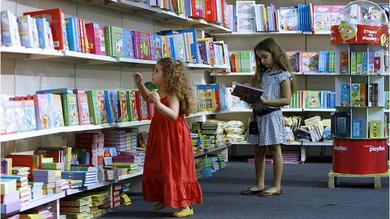 Two girls pick books from the children's